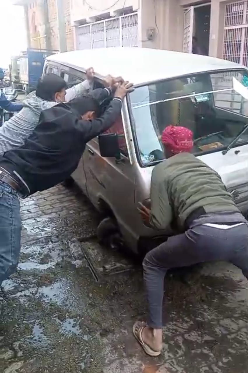 कोंच: लापरवाही की हद! खुले सीवर चेंबर में फंसी स्कूल वैन, बाल-बाल बचे स्कूली बच्चे; चीख-पुकार से दहला मोहल्ला जालौन के कोंच में खुले सीवर चेंबर में फंसी स्कूली बच्चों की वैन और मदद करते स्थानीय लोग।