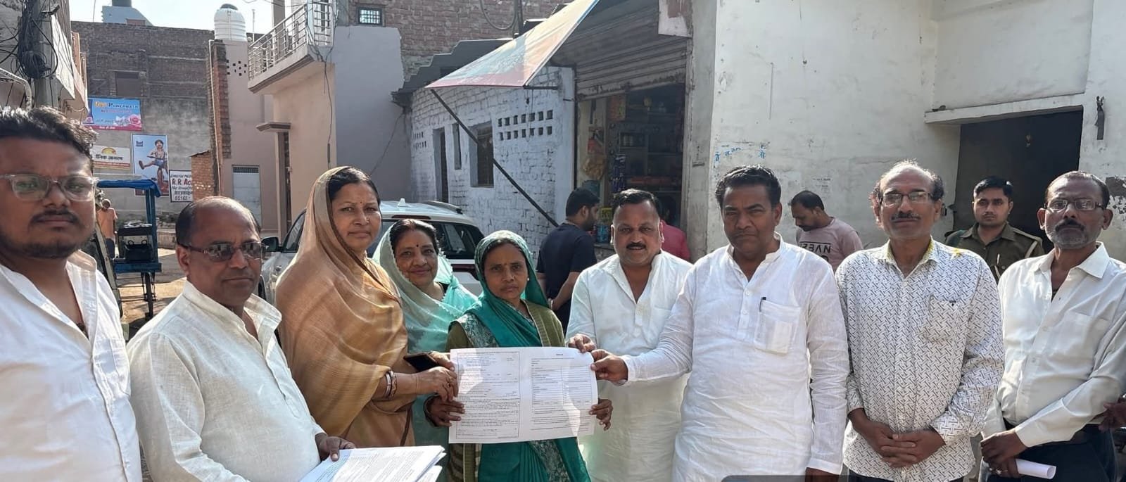 कोंच में मतदाता पुनरीक्षण अभियान के दौरान मोहल्ला जयप्रकाश नगर में स्थानीय नागरिकों को मतदाता फॉर्म वितरित करते भाजपा विधायक मूलचंद्र निरंजन और अन्य पार्टी पदाधिकारी।