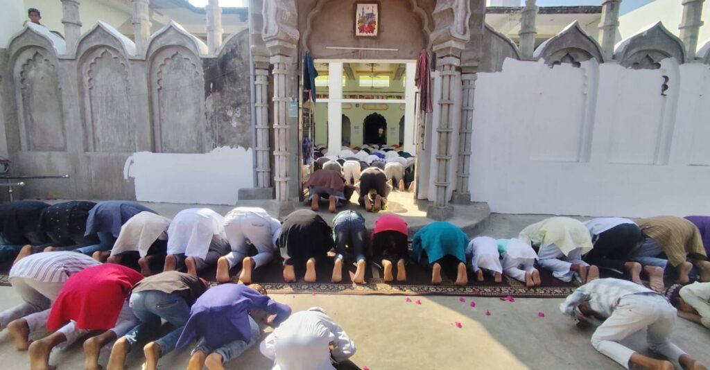 उत्तर प्रदेश के जालौन जिले के कोंच नगर में रमजान के पहले जुमे पर मस्जिद में नमाज अदा करते नमाजी और सुरक्षा व्यवस्था में तैनात पुलिस बल