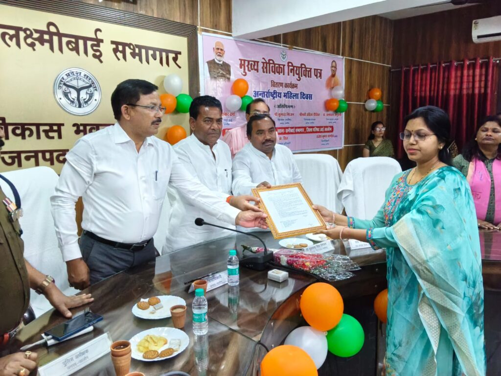 उरई के विकास भवन में आयोजित कार्यक्रम के दौरान जिला पंचायत अध्यक्ष डॉ. घनश्याम अनुरागी, विधायक मूलचंद्र निरंजन और जिलाधिकारी राजेश कुमार पाण्डेय द्वारा महिलाओं को नियुक्ति पत्र वितरित करते हुए