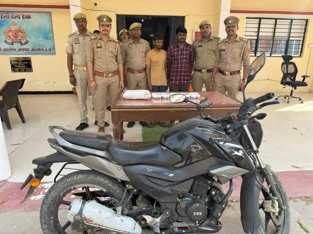 जालौन पुलिस की बड़ी कामयाबी: 38 मुकदमों वाले दो शातिर अंतरजनपदीय चोर गिरफ्तार, लाखों की नगदी व जेवरात बरामद news image जालौन पुलिस की गिरफ्त में खड़े दो शातिर अंतरजनपदीय चोर, सामने मेज पर बरामद नकद राशि, जेवरात और मोबाइल फोन रखे हुए हैं