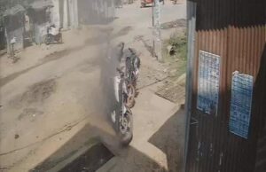 जालौन के एट कोतवाली क्षेत्र में हाईटेंशन तार गिरने से धू-धू कर जलती हुई मोटरसाइकिल और आसपास जमा भीड़