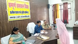 जालौन तहसील सभागार में आयोजित सम्पूर्ण समाधान दिवस के दौरान उपजिलाधिकारी हेमंत पटेल और अन्य अधिकारी फरियादियों की शिकायतों को सुनते हुए