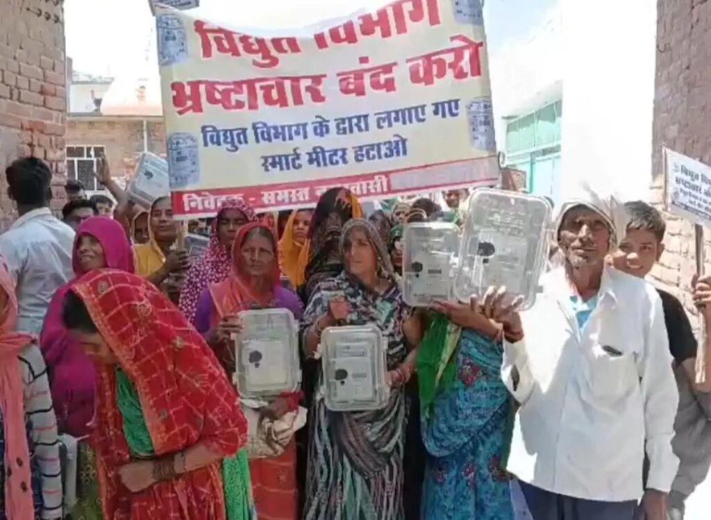 जालौन के माधौगढ़ में हाथों में स्मार्ट मीटर लेकर सड़क पर प्रदर्शन करतीं सैकड़ों महिलाएं और सुरक्षा में तैनात पुलिस बल