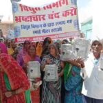 जालौन के माधौगढ़ में हाथों में स्मार्ट मीटर लेकर सड़क पर प्रदर्शन करतीं सैकड़ों महिलाएं और सुरक्षा में तैनात पुलिस बल