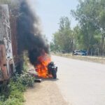 जालौन के उरई में कालपी रोड पर धू-धू कर जलती हुई बाइक और बचाव कार्य में जुटे पुलिसकर्मी एवं स्थानीय लोग