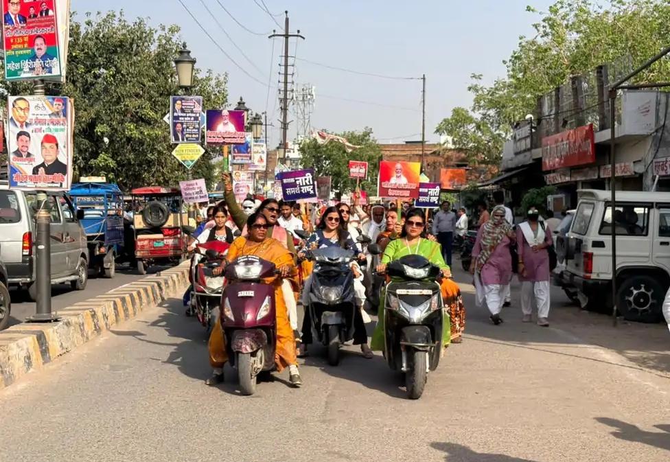 जालौन में भाजपा महिला मोर्चा की स्कूटी रैली के दौरान बिना हेलमेट स्कूटी चलातीं जिलाध्यक्ष उर्विजा दीक्षित और अन्य महिला पदाधिकारी