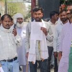 बरहल गांव उरई में पीड़ित का घर, टूटी अलमारी और ताले के साथ घटनास्थल का दृश्य, आसपास खड़े ग्रामीण और जांच करती पुलिस