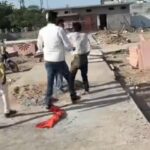 उरई के शहीद स्मारक परिसर में निर्माण स्थल पर भीड़ के बीच एक मजदूर के साथ मारपीट का दृश्य