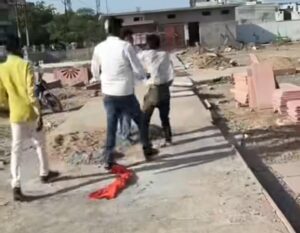 उरई के शहीद स्मारक परिसर में निर्माण स्थल पर भीड़ के बीच एक मजदूर के साथ मारपीट का दृश्य