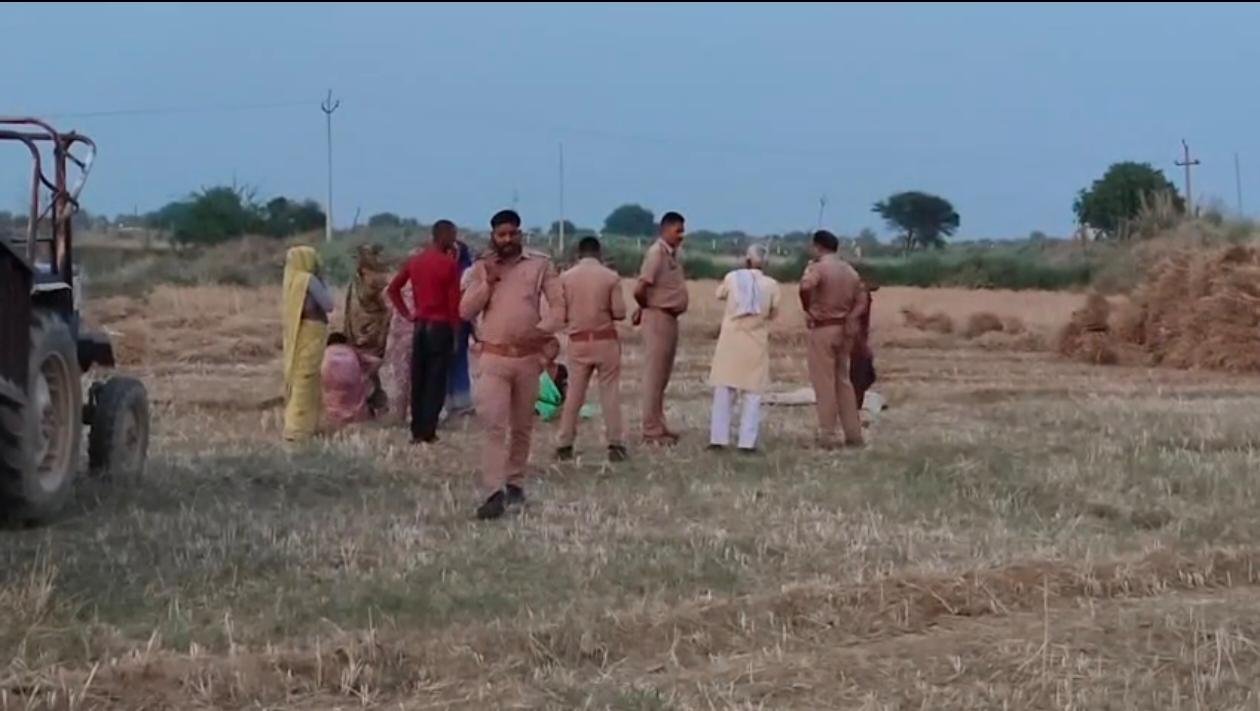 खेत में पुलिस जांच के दौरान लहूलुहान हालत में पड़े दो लोगों के शव, आसपास जुटी भीड़ और मौके पर मौजूद पुलिस टीम का दृश्य