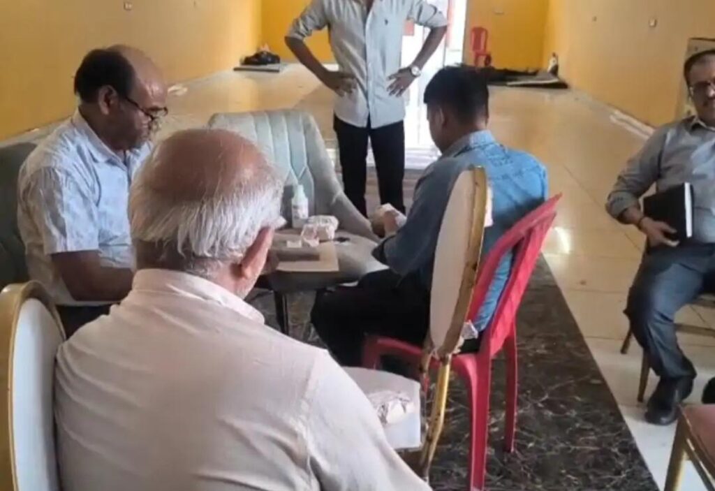 उरई में खाद्य विभाग के अधिकारी बी.के. राय की टीम दुकान से पनीर और खोये के नमूने एकत्र करते हुए, पीछे पुलिस और स्थानीय लोगों की भीड़