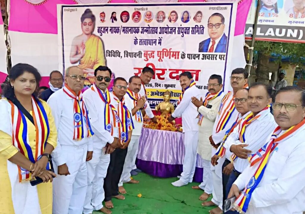 उरई के डॉ. अंबेडकर चौराहे पर बुद्ध जयंती के अवसर पर आयोजित खीरदान कार्यक्रम में उमड़ी श्रद्धालुओं की भीड़ और पुष्प अर्पित करते गणमान्य नागरिक