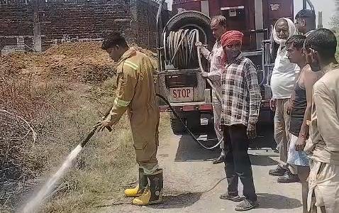 जालौन के कोंच क्षेत्र में एक बिजली ट्रांसफार्मर के पास सूखे कचरे के ढेर से उठती भीषण आग की लपटें और काला धुआं, ग्रामीण और दमकलकर्मी आग बुझाने का प्रयास करते हुए।