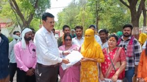 जालौन कलेक्ट्रेट परिसर में हाथों में न्याय की मांग वाली तख्तियां लेकर विरोध प्रदर्शन करतीं ग्रामीण महिलाएं और स्थानीय नागरिक