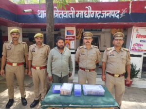 जालौन की माधौगढ़ कोतवाली पुलिस की गिरफ्त में आईपीएल मैच पर ऑनलाइन सट्टा लगाने वाला मुख्य आरोपी पवन मिसुरिया, जिसके सामने टेबल पर बरामद कैश और मोबाइल फोन रखा है।