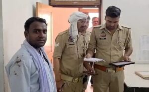 कदौरा विकास खंड कार्यालय में मनरेगा पटल पर घायल ग्राम रोजगार सेवक ब्रजेन्द्र कुमार, जिनके सिर पर पट्टी बंधी है और पृष्ठभूमि में पुलिस बल व ब्लॉक कर्मचारी मौजूद हैं।