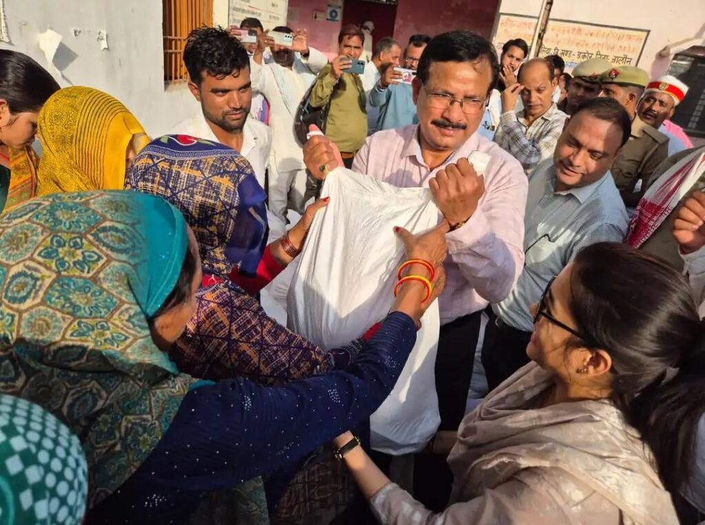उत्तर प्रदेश के जालौन जिले के कुसमिलिया गांव में भीषण आग लगने के बाद जले हुए मकानों का निरीक्षण करते जिलाधिकारी राजेश कुमार पाण्डेय और प्रशासनिक अधिकारी, साथ में राहत सामग्री प्राप्त करते पीड़ित ग्रामीण।