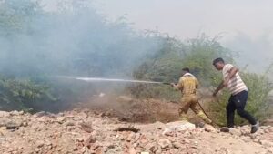 उत्तर प्रदेश के जालौन जिले में कोंच तहसील के छिरावली गांव के पास जंगल में लगी भीषण आग की लपटें और धुएं का गुबार, जिसे बुझाने का प्रयास करते ग्रामीण और दमकलकर्मी।