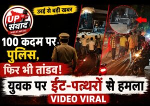 जालौन के उरई कोतवाली क्षेत्र के अजनारी रोड पर स्थित शराब ठेके के बाहर लाठी-डंडों और ईंट-पत्थरों से एक युवक को बेरहमी से पीटते हुए दबंगों का वायरल वीडियो स्क्रीनशॉट, जिसमें एक महिला बीच-बचाव करने की कोशिश कर रही है और पृष्ठभूमि में भीड़ तमाशबीन बनी खड़ी है।