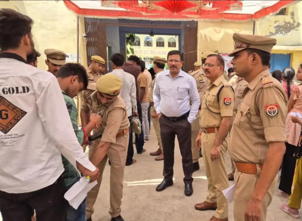 यूपी पुलिस भर्ती परीक्षा का पहला दिन: जालौन में कड़े पहरे के बीच नकलविहीन और शांतिपूर्ण ढंग से परीक्षा संपन्न, पहले दिन 1,410 अभ्यर्थी रहे अनुपस्थित news image उत्तर प्रदेश पुलिस भर्ती परीक्षा 2026 के दौरान जालौन के एक परीक्षा केंद्र पर अभ्यर्थियों का बायोमेट्रिक सत्यापन और सघन तलाशी लेते सुरक्षाकर्मी, पृष्ठभूमि में निरीक्षण करते जिलाधिकारी और पुलिस अधीक्षक।