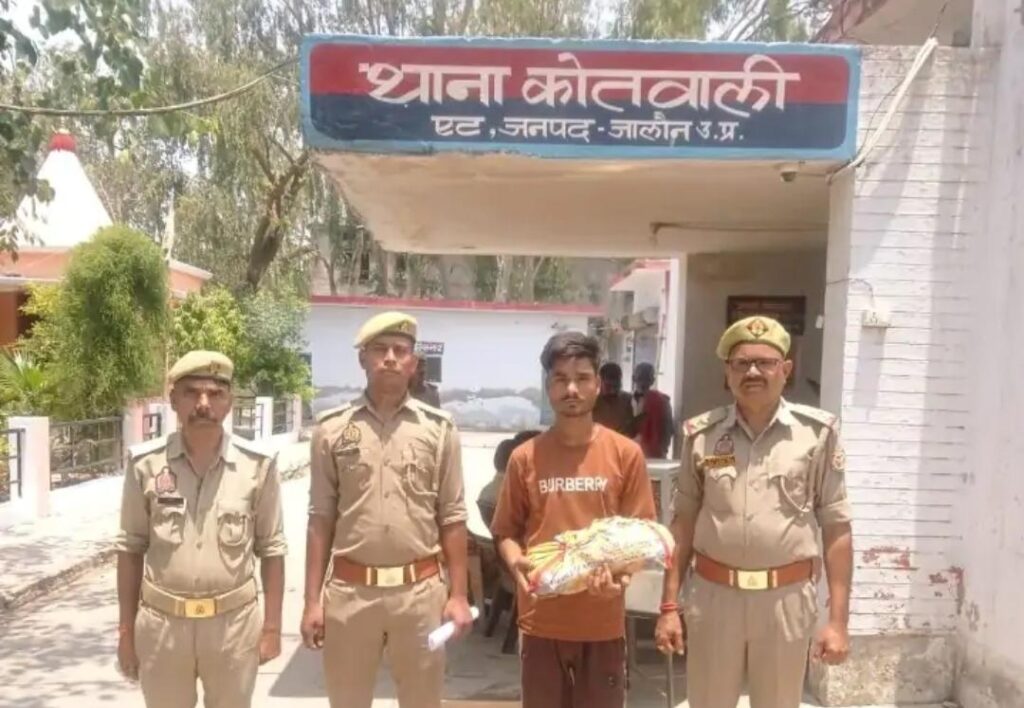जालौन के थाना एट पुलिस टीम की कस्टडी में खड़ा अवैध गांजा तस्करी का आरोपी विवेक अहिरवार और टेबल पर बरामद किया गया पैक्ड गांजा।