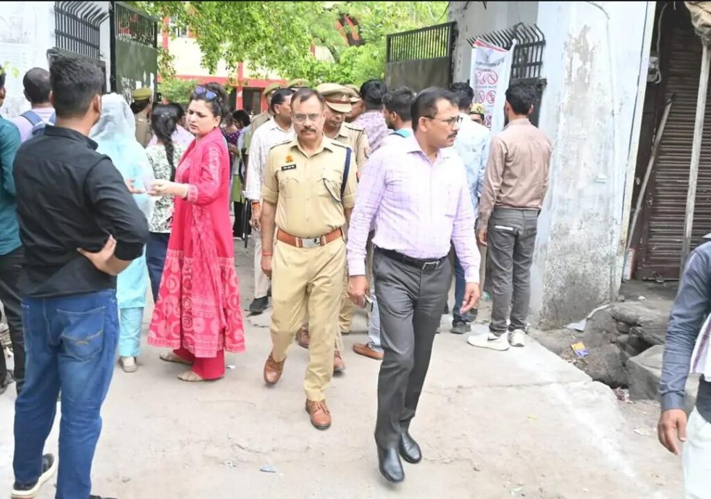 जालौन के एक परीक्षा केंद्र पर यूपी पुलिस कांस्टेबल भर्ती परीक्षा के दौरान बायोमेट्रिक सत्यापन और सुरक्षा जांच से गुजरते परीक्षार्थी तथा निरीक्षण करते जिलाधिकारी राजेश कुमार पाण्डेय।