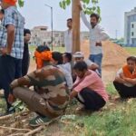 जालौन के सिरसाकलार में सड़क हादसे के बाद घटनास्थल पर जुटी पुलिस और ग्रामीणों की भीड़, पास में क्षतिग्रस्त बाइक और बिखरे हुए शादी के कार्ड।
