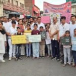 योगमय हुआ उरई: 12वें अंतर्राष्ट्रीय योग दिवस की पूर्व संध्या पर भव्य जन-जागरूकता रैली, उमड़ा 4 हजार लोगों का सैलाब उरई के टाउन हॉल परिसर में 12वें अंतर्राष्ट्रीय योग दिवस की पूर्व संध्या पर आयोजित भव्य जन-जागरूकता रैली को हरी झंडी दिखाकर रवाना करते सदर विधायक गौरी शंकर वर्मा, जिलाधिकारी राजेश कुमार पांडेय और सीडीओ के.के. सिंह। पृष्ठभूमि में हाथों में बैनर और तख्तियां लिए हजारों उत्साही प्रतिभागी।