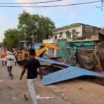 जालौन में बड़ा बवाल: अतिक्रमण हटाओ अभियान के दौरान भारी पथराव, नगर पंचायत के 3 कर्मी घायल, बुलडोजर के शीशे तोड़े जालौन के कदौरा में हरचंदपुर रोड पर अतिक्रमण हटाओ अभियान के दौरान भारी पुलिस बल की मौजूदगी और क्षतिग्रस्त बुलडोजर के पास खड़े प्रशासनिक अधिकारी।