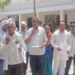 जालौन के पहाड़गांव में गहराया पेयजल संकट: दो वर्षों से सूखी पड़ी है पाइपलाइन, 800 मीटर दूर से पानी ढोने को मजबूर ग्रामीण जालौन के पहाड़गांव में खाली बर्तन लेकर खड़ीं ग्रामीण महिलाएं और 800 मीटर दूर से पानी लाते बच्चे, जो जल संकट को लेकर विरोध प्रदर्शन कर रहे हैं।