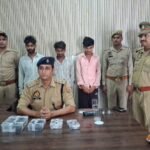 जालौन में 'WALA' एप के जरिए नग्न वीडियो बना ब्लैकमेल करने वाले अंतर्राज्यीय गिरोह का पर्दाफाश, तीन दबोचे जालौन की कालपी कोतवाली पुलिस की गिरफ्त में खड़े साइबर ब्लैकमेलिंग और रंगदारी वसूलने वाले गिरोह के तीन आरोपी, जिनके सामने टेबल पर बरामद नकदी, मोबाइल फोन और तमंचा-कारतूस रखे हुए हैं।