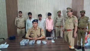 जालौन की कालपी कोतवाली पुलिस की गिरफ्त में खड़े साइबर ब्लैकमेलिंग और रंगदारी वसूलने वाले गिरोह के तीन आरोपी, जिनके सामने टेबल पर बरामद नकदी, मोबाइल फोन और तमंचा-कारतूस रखे हुए हैं।