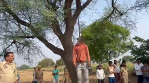Jalaun Crime News, Kuthaund Police Station, Bawali Village Jalaun, Jalaun Breaking News, Suspicious Death Jalaun, Suicide Case UP, UP Crime Investigation, Jalaun Police Action, Bundelkhand Crime Update, बवाली गांव जालौन, कुठौंद थाना पुलिस, जालौन सुसाइड खबर, बबूल के पेड़ से लटका शव, यूपी क्राइम न्यूज़, जालौन सनसनीखेज मामला, ग्रामीण क्षेत्र अपराध, पोस्टमार्टम रिपोर्ट जालौन, यूपी पुलिस जांच, Jalaun District News, Orai Jalaun Crime, Local News Jalaun, UP Samvad Focus, Jalaun News Today, Sandigdha Maut Kuthaund, Jalaun Police Liveजालौन के कुठौंद थाना क्षेत्र के ग्राम बवाली के बाहर खेतों में खड़े बबूल के पेड़ के पास जुटी ग्रामीणों और पुलिस बल की भारी भीड़, पुलिसकर्मी घटनास्थल का मुआयना करते हुए और रोते-बिलखते परिजन, खोजी और संवेदनशील माहौल को दर्शाती तस्वीर।