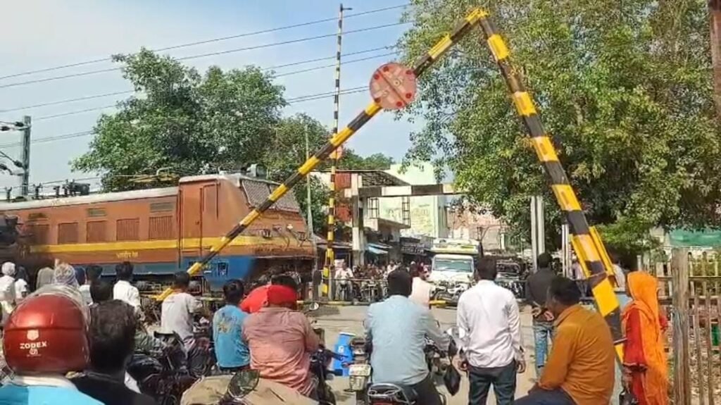 जालौन के कोंच क्षेत्र में अज्ञात वाहन की टक्कर से टूटा हुआ रेलवे क्रॉसिंग का बैरियर और वहां से जोखिम उठाकर गुजरते वाहन चालक।