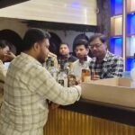 जालौन के उरई कोतवाली क्षेत्र स्थित मून बार में छापेमारी के दौरान कार्रवाई करती हुई आबकारी विभाग और पुलिस की टीम, बरामद शराब की बोतलें और कैन।