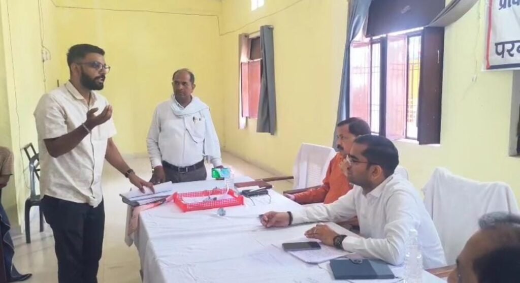 जालौन के नदीगांव में संपूर्ण समाधान दिवस कक्ष के बाहर नगर पालिका अधिनियम की किताब लेकर धरने पर बैठे सभासद अमित कुमार।