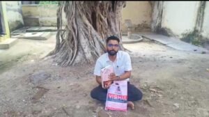जालौन के नदीगांव में संपूर्ण समाधान दिवस कक्ष के बाहर नगर पालिका अधिनियम की किताब लेकर धरने पर बैठे सभासद अमित कुमार।
