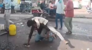 जालौन के उरई में राठ रोड ओवरब्रिज के नीचे बीच सड़क दो युवकों के बीच मारपीट का दृश्य, मौके पर जुटी भीड़ और घटना का वीडियो बनाते लोग।