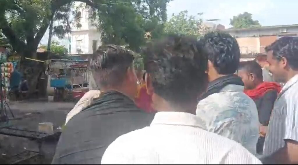 जालौन के उरई में राठ रोड ओवरब्रिज के नीचे बीच सड़क दो युवकों के बीच मारपीट का दृश्य, मौके पर जुटी भीड़ और घटना का वीडियो बनाते लोग।