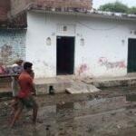 करमेर गांव में कीचड़ भरे रास्ते से चारपाई पर बीमार महिला को ले जाते ग्रामीण