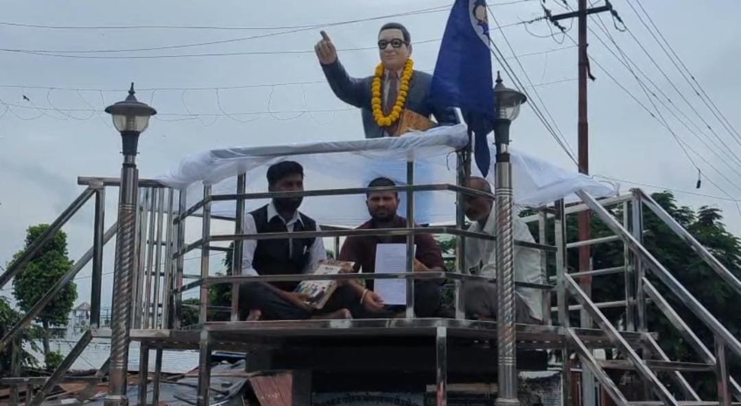 उरई कोतवाली क्षेत्र के अंबेडकर चौराहे पर प्रतिमा के नीचे धरने पर बैठे लोग