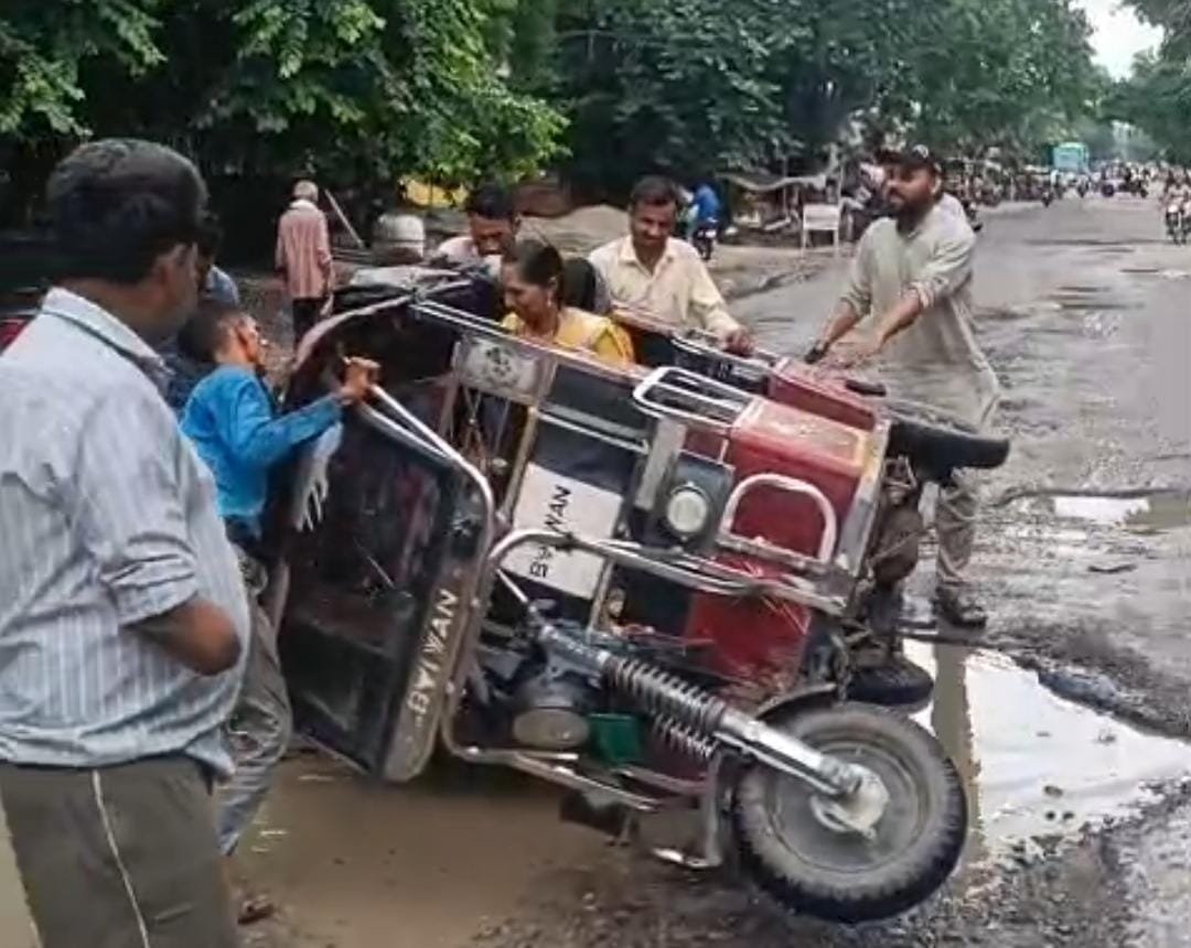 कोंच-नदीगांव मार्ग पर जिओ ऑफिस के सामने क्षतिग्रस्त सड़क और गड्ढा