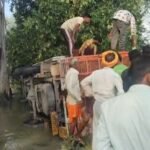 खंती में पलटी लोडर से मुर्गों को निकालते ग्रामीण