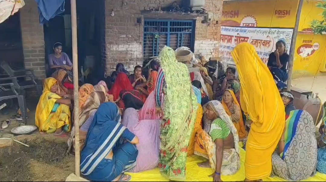 मृतक किसान घर के बाहर बैठे हुए लोग